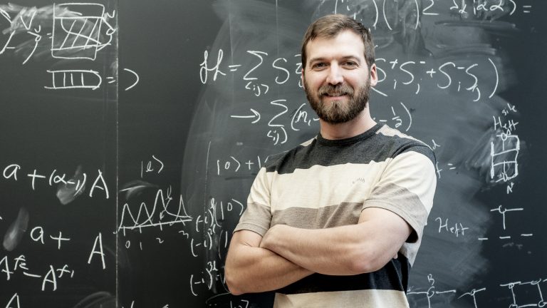 Un homme debout devant un tableau d'équations