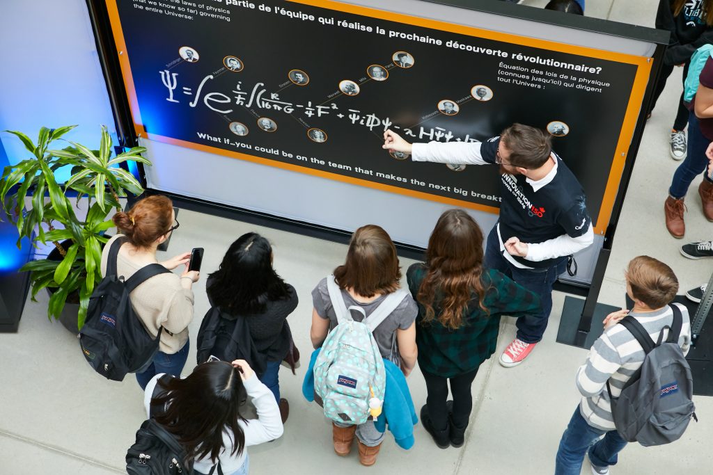 Vue aérienne d'une instructrice montre une équation à des d'élèves du secondaire sur un tableau noir